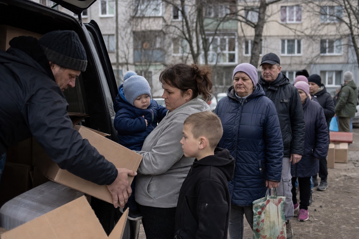 Волонтери передають коробки з допомогою родині
